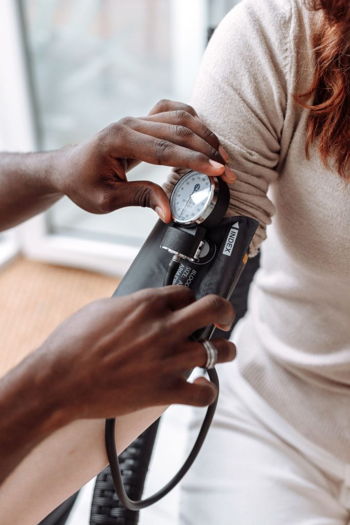 A health professional checking a patient’s blood pressure